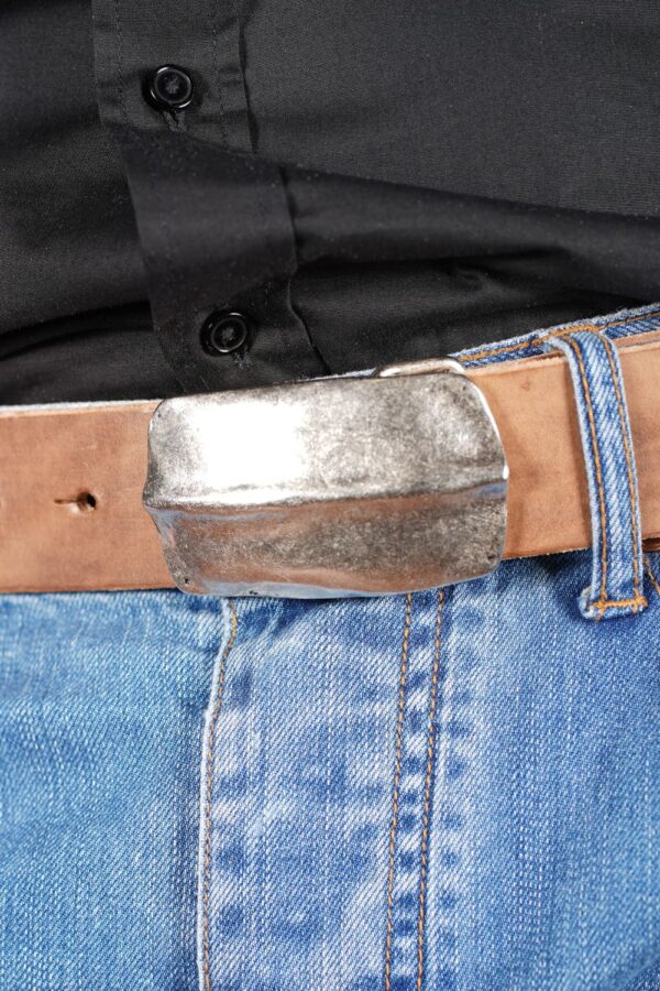 bMS Schild 4cm Ledergürtel ROUGH NATURE - Nahaufnahme an heller Jeans und schwarzem Hemd (Ausschnitt)